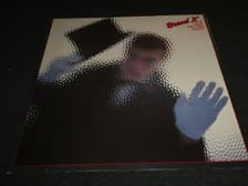 Tumnagel för auktion "Brand X - Is there anything about? - NED LP - 1982 - Jazz-Rock-Funk"