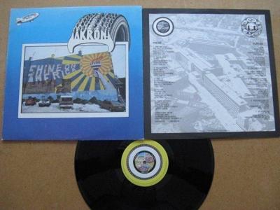 Tumnagel för auktion "Akron Compilation. 1978 UK Stiff. New Wave/Rock V/A. Pic/textsl."