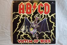 Tumnagel för auktion "AB/CD – Victim Of Rock Vinyl Mini-Album"