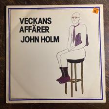 Tumnagel för auktion "JOHN HOLM - Veckans Affärer 1976. Originalinner! Prog-rock. Punk. New Wave. LP"