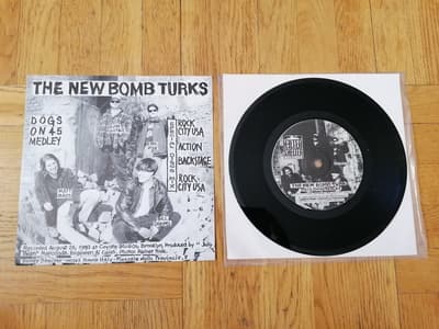 Tumnagel för auktion "The New Bomb Turks / The Devil Dogs – Split 7" (Helter Skelter Records, 1993)"