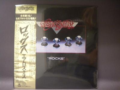 Tumnagel för auktion "AEROSMITH - ROCKS - JAPAN PRESS - OBI - INPLASTAD"